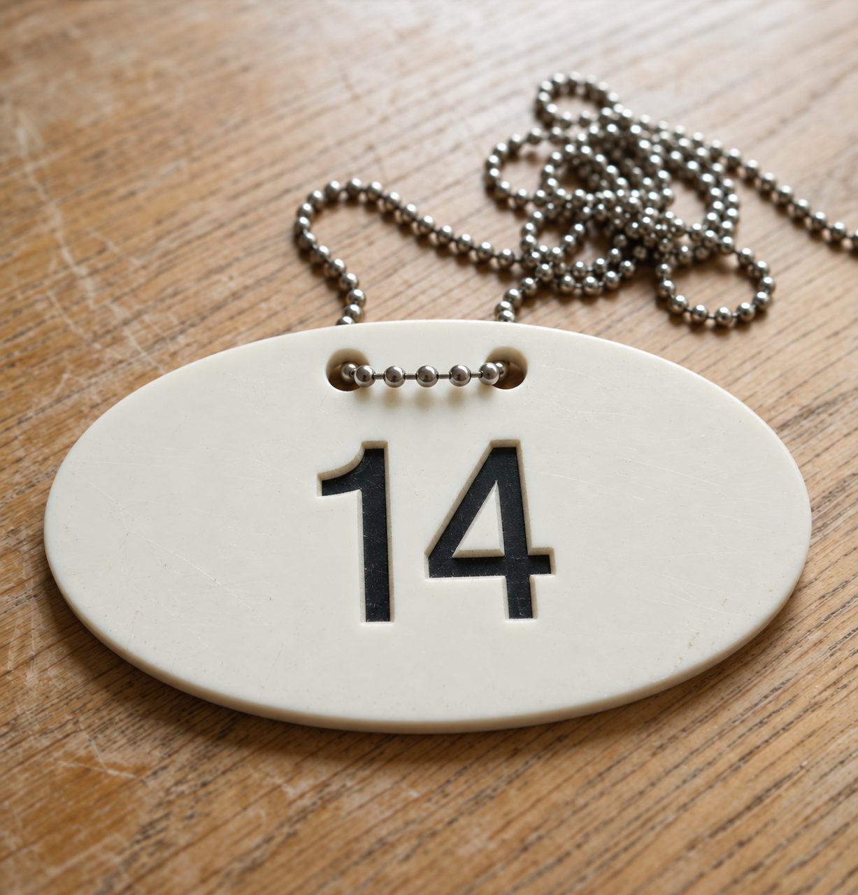 Oval number 14 tag on a ball chain